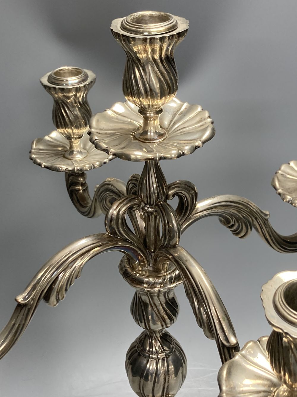 An early 20th century continental 830 white metal four branch, five light candelabrum,